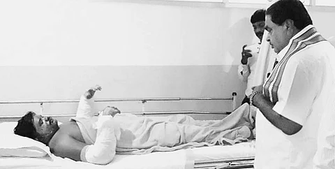 Forest Minister B Ramanath Rai enquiring about the health of a forest official who sustained burns while dousing fire at Bandipur National park in Mysuru on Tuesday