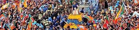 Prime Minister and Bharatiya Janata Party leader Narendra Modi greets people during a massive roadshow to muster support for his party’s candidates in the Uttar Pradesh Assembly elections, in Varanasi on Sunday. Campaigning for the seventh and final phase