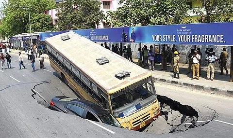 The car and bus that sank into the crater on Anna Salai on Sunday. | Express File Photo
