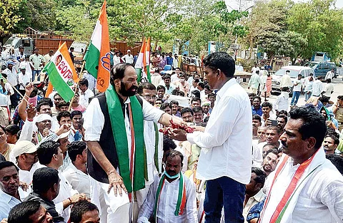 TPCC chief N Uttam Kumar Reddy interacting with a chilli farmer at Enumamula market yard in Warangal on Monday | express photo