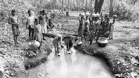 Villagers collecting water from a nullah in Anantapur reserve forest of Dhenkanal district | Express