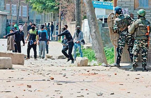 Protestors clash with security personnel near a polling station in Srinagar on Sunday. | EPS