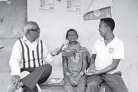 Prof K Ramesh Kumar, former professor of Osmania University’s Linguistics dept interacts with a two Remo tribals at Malkangiri in Odisha | Express photo