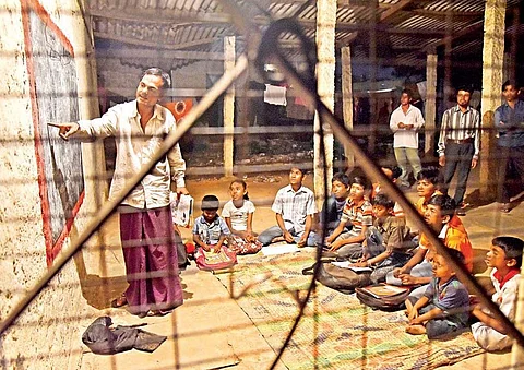 Shamsul Alam, a refugee, teaching children and adults at Rohingya refugee camp at Balapur in Hyderabad on Friday | R Satish Babu