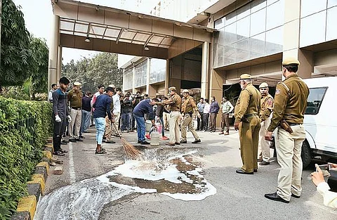 Policemen guard as a worker cleans the spot after ACP-rank police officer Prem Ballabh allegedly committed suicide by jumping off the Delhi Police headquarters building in New Delhi on Thursday (EPS | Parveen Negi)