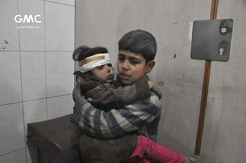 Two Syrian kids who were wounded during airstrikes and shelling by Syrian government forces, sit at a makeshift hospital, in Ghouta, suburb of Damascus, Syria. | AP