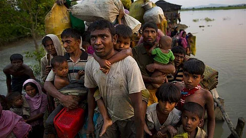 Rohingya Muslims carry their children and belongings after crossing the border from Myanmar into Bangladesh. (File | AP)