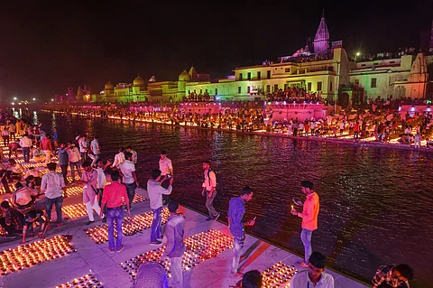 Devotees light earthen lamps on the bank of Saryu River during Deepotsav celebrations in Ayodhya. (Photo | PTI)