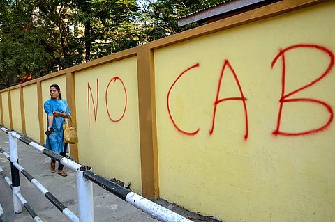 A pedestrain walks past a wall graffiti opposing the Citizenship Amendment Bill (CAB) in Guwahati. (Photo | PTI)
