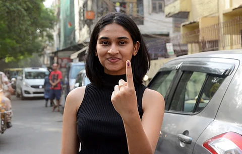 A first time voter shows her finger with indelible ink mark after casting her vote at a polling station at Rajinder Nagar in New Delhi on Sunday. | (Naveen Kumar | EPS)