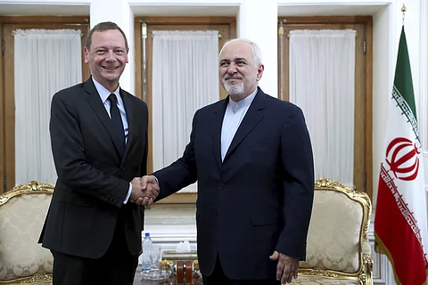 Iranian Foreign Minister Mohammad Javad Zarif, right, shakes hand with French presidential envoy Emmanuel Bonne, as they pose for photos, in Tehran, Iran, Wednesday, July 10, 2019. France sent Bonne to Tehran to urge Iran to return to complying with the t