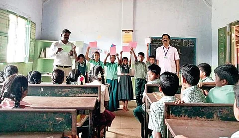 Education department officials checking the learning skills of the students of a government school at Odayakulam in Anaimalai block