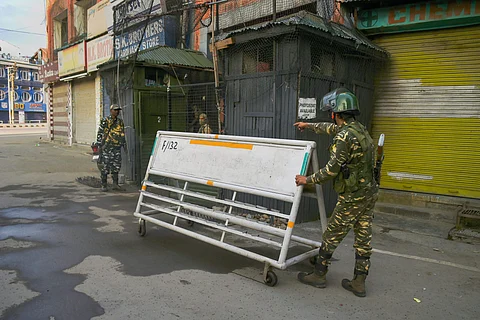 A security personnel pushes a barricade during restriction on fifth consecutive day in Srinagar Friday August 9 2019. | PTI