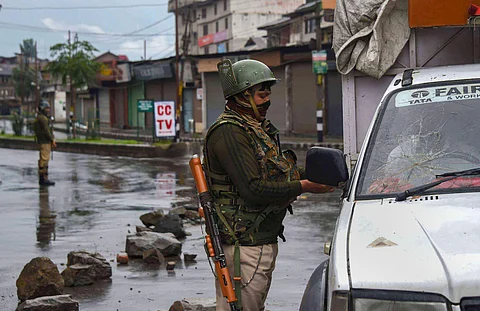 A Security person checks the identity card of a driver during curfew like restrictions following abrogation of the provisions of Article 370 in Srinagar Wednesday August 14 2019. | PTI