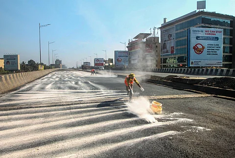 Workers spread a powder for the repairment of the Andheri flyover road during ongoing COVID-19 lockdown in Mumbai. (Photo | PTI)