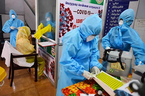 Health workers take nasal swabs from a woman through a Covid-19 sample collection kiosk installed at Public Health Laboratory and Health Care Center at Pudupet in Chennai. (Photo | Debdatta Mallick, EPS)