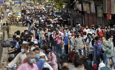Migrants gather outside Dharavi slum to board buses for a railway station for their onward journey by special train to reach their native places during ongoing COVID-19 lockdown in Mumbai Sunday May 24 2020. (Photo | PTI)