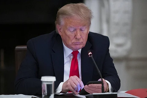 US President Donald Trump looks at his phone during a roundtable with governors on the reopening of America's small businesses, in the State Dining Room of the White House, Thursday, June 18, 2020, in Washington. (Photo | AP)