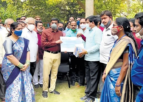 Srikakulam planning department officials hand over a cheque to Collector J Nivas