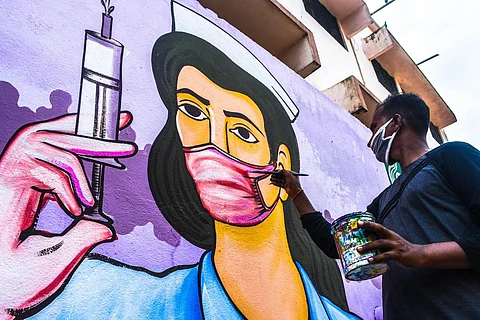 An artist busy painting on walls over theme of COVID-19 in Bhubaneswar (File photo| Biswanath Swain, EPS)