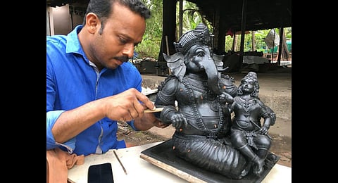 Rajendran T V working on a wax model of Lord Ganesha and Lord Krishna before casting the idol in bronze, at his foundry at Kunhimangalam.