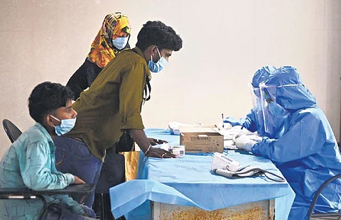 Health workers advising people before taking swab samples at Rajiv Gandhi GH | DEBADATTA MALLICK