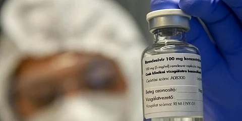 A bottle containing the drug Remdesivir is held by a health worker. (Photo | AP)