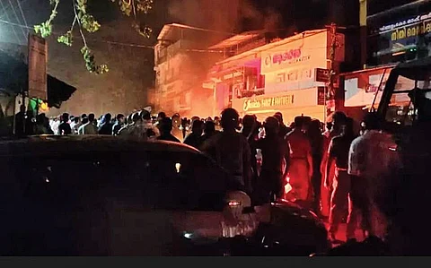 People gather in front of the CPM local committee office at Peringathur which was set on fire allegedly by Muslim League workers.