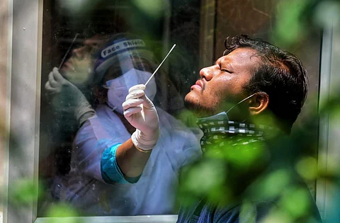 Health officers collect swab samples for COVID-19 tests amid surge in coronavirus cases.
