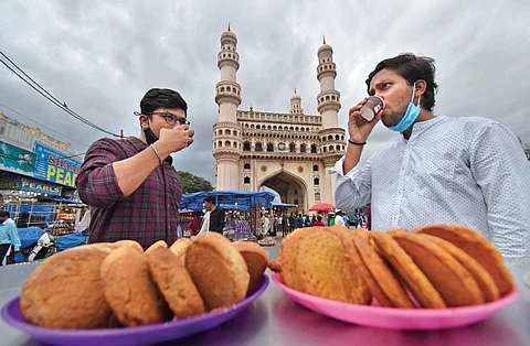 People having tea and biscuits in Hyderabad. (Photo | S Senbagapandiyan, EPS)