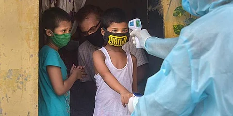 Volunteers carry out thermal testing for children (Photo | PTI)