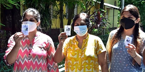 Voters show their voter id card at polling booth during the Bhabanipur by-polls, in Kolkata on Thursday. (Photo | ANI)