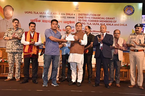 Assam Chief Minister Himanta Biswa Sarma distributes a one-time financial grant to one of the 318 surrendered militants during a programme in Guwahati. (Special Arrangement)