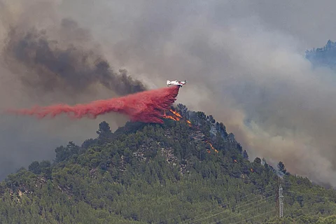 A firefighting plane drops retardant on a forest fire in the Castellgali area of Catalonia, Spain on July 17, 2022. (Photo | AP)