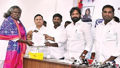 Tourism & Culture Minister V Srinivas Goud presents documents for 600 square yards of plot to Kinnera player Mogilaiah in Hyderabad on Thursday