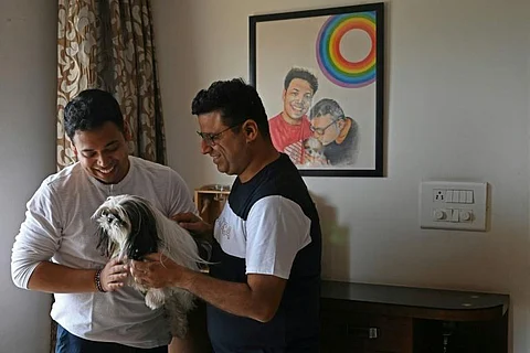 Abhay Dang (R) and Supriyo Chakraborty, who have petitioned India’s Supreme Court to legalise same-sex marriages, pose for a picture with their dog at their home in Hyderabad. (Photo | AFP)