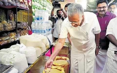 Chief Minister Pinarayi Vijayan checking the quality of grains at the Consumerfed’s outlet at Gandhi Nagar in Kochi after inaugurating its Onam fair on Sunday | express