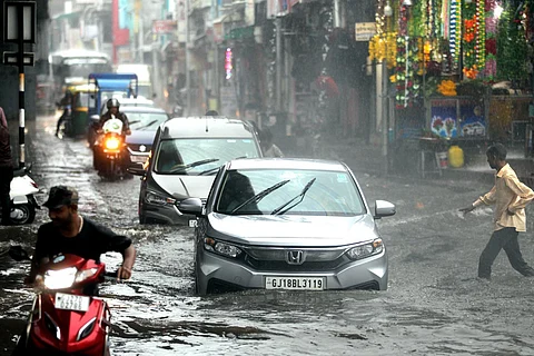 Vehicles pass through a waterlogged road amid heavy rains, in Ahmedabad on Sunday. (Photo | PTI)