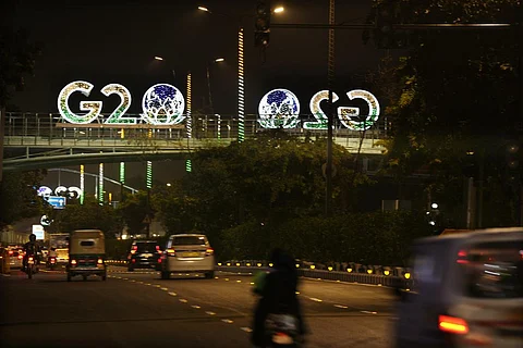 FILE - G20 logos are illuminated with the colors of the Indian flag on a pedestrian bridge in New Delhi. (Photo | AP)