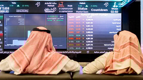 متعاملون يتابعون مؤشر سوق الأسهم