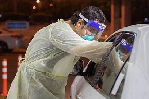 أحد الأطقم الطبية يجري مسحة كورونا