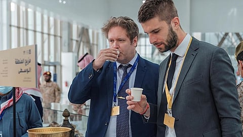 زوار معرض الدفاع العالمي يحتسون القهوة السعودية