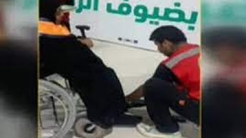 متطوع يساعد حاجه عراقية