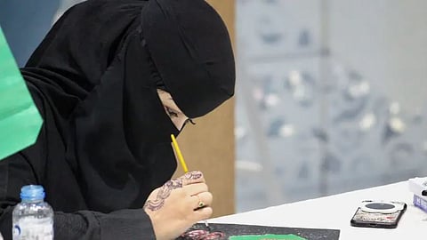 هدى الصيخان.. فنانة سعودية تتحدى إعاقتها بالرسم على القصدير