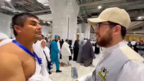أحد منسوبي الترجمة يرشد معتمرًا