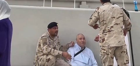 أحد رجال الأمن يقدم المساعدة لحاج