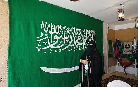 بالصور.. مُسِنّة تعكف 7 أشهر لتصنع أكبر علم سعودي من "السدو"