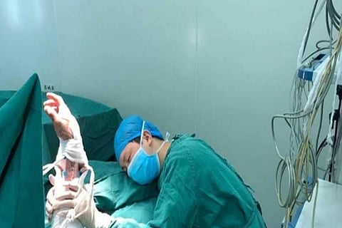 بعد 20 ساعة من العمل.. طبيب صيني ينام داخل غرفة العمليات