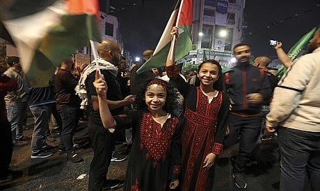 Palestinians celebrate in Ramallah city center in support of the resistance in Gaza, after the cease-fire between the Palestinians and Israel late in the early hours of May 21, 2021, in Ramallah, in the Israeli-occupied West Bank. - A ceasefire between Israel and Hamas, the Islamist movement which controls the Gaza Strip, came into force early Friday after 11 days of deadly fighting that pounded the Palestinian enclave and forced countless Israelis to seek shelter from rockets. (Photo by ABBAS MOMANI / AFP)