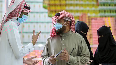 A man displays his details on his mobile phone using the Tawakkalna app, which was launched by Saudi authorities to track people infected with the coronavirus disease (COVID-19), as he enters the Al-Othaim market in Riyadh, Saudi Arabia February 22, 2021. (Reuters)